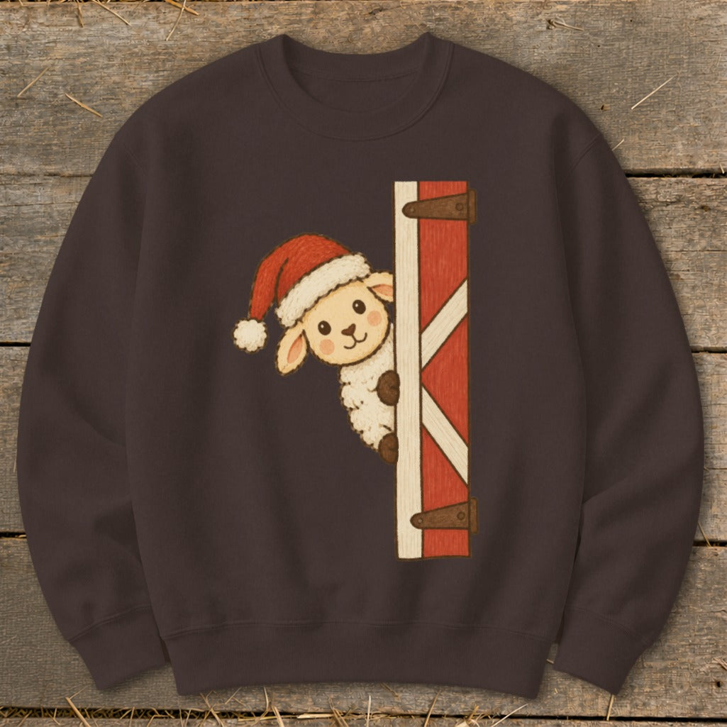 Sheep wearing Santa hat peeking from barn door on dark brown sweatshirt.