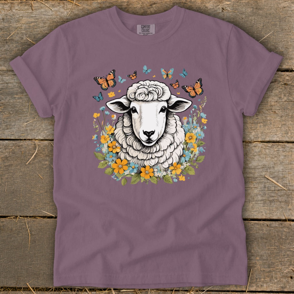 Sheep with butterflies and flowers graphic on a mauve t-shirt.