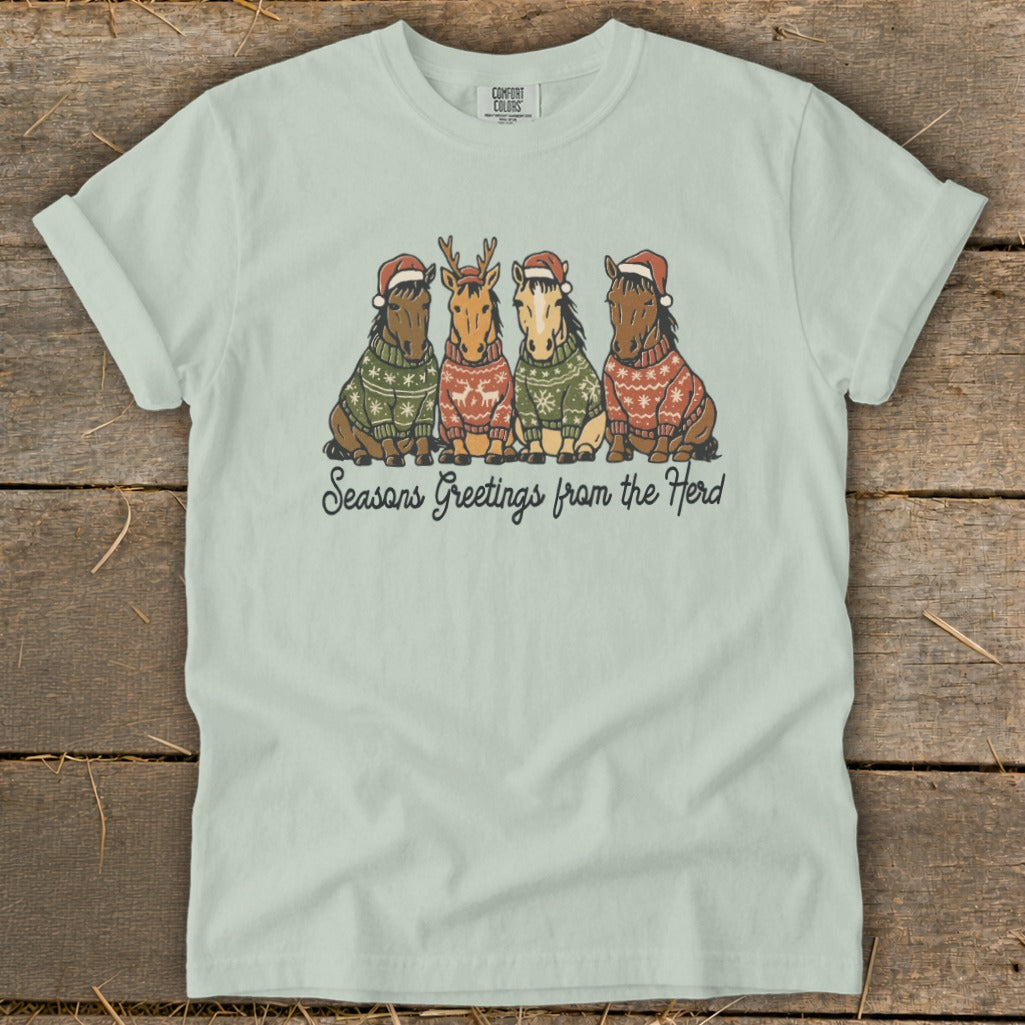 Four horses wearing Christmas sweaters and hats with text "Seasons Greetings from the Herd".
