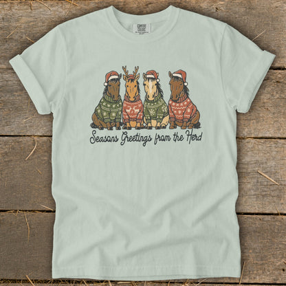 Four horses wearing Christmas sweaters and hats with text "Seasons Greetings from the Herd".