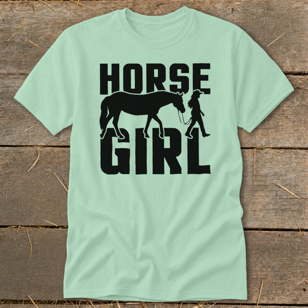 Light green t-shirt with black text and graphic of a horse and girl.