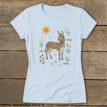 Light blue t-shirt with a watercolor illustration of a donkey, sun, flowers, and waves.