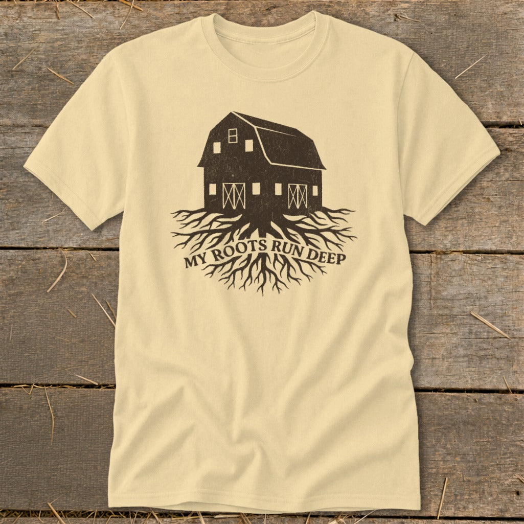 Light yellow t-shirt with a dark brown graphic of a barn and tree roots, text reads "MY ROOTS RUN DEEP".