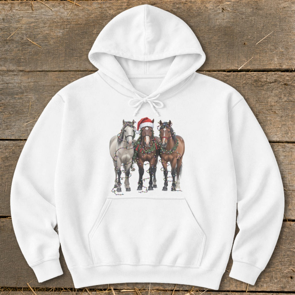Three horses, one in a Santa hat, wearing Christmas lights on a white hoodie.