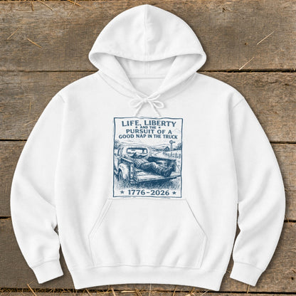 White hoodie with a graphic of a man napping in a truck bed, text "Life, Liberty and the Pursuit of a Good Nap in the Truck".