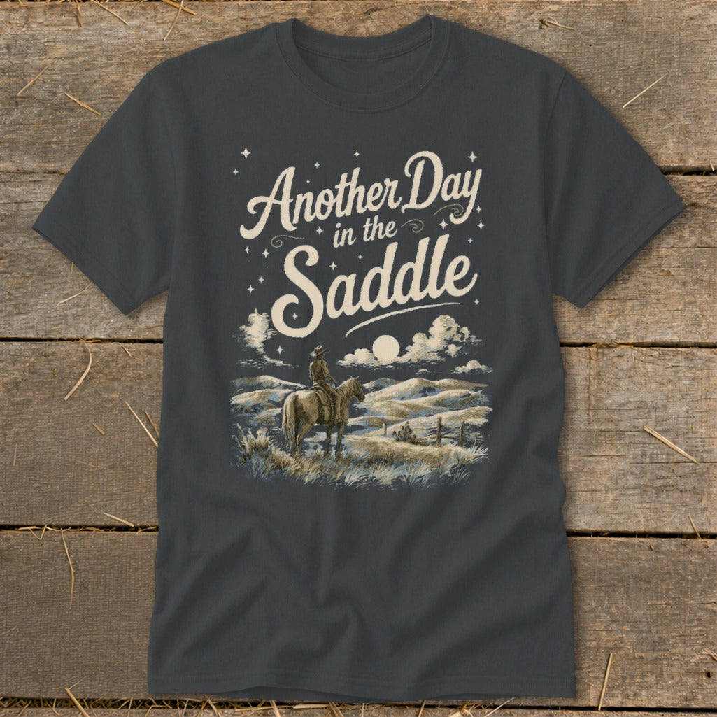 Dark grey t-shirt with "Another Day in the Saddle" graphic of a cowboy on horseback at dusk.