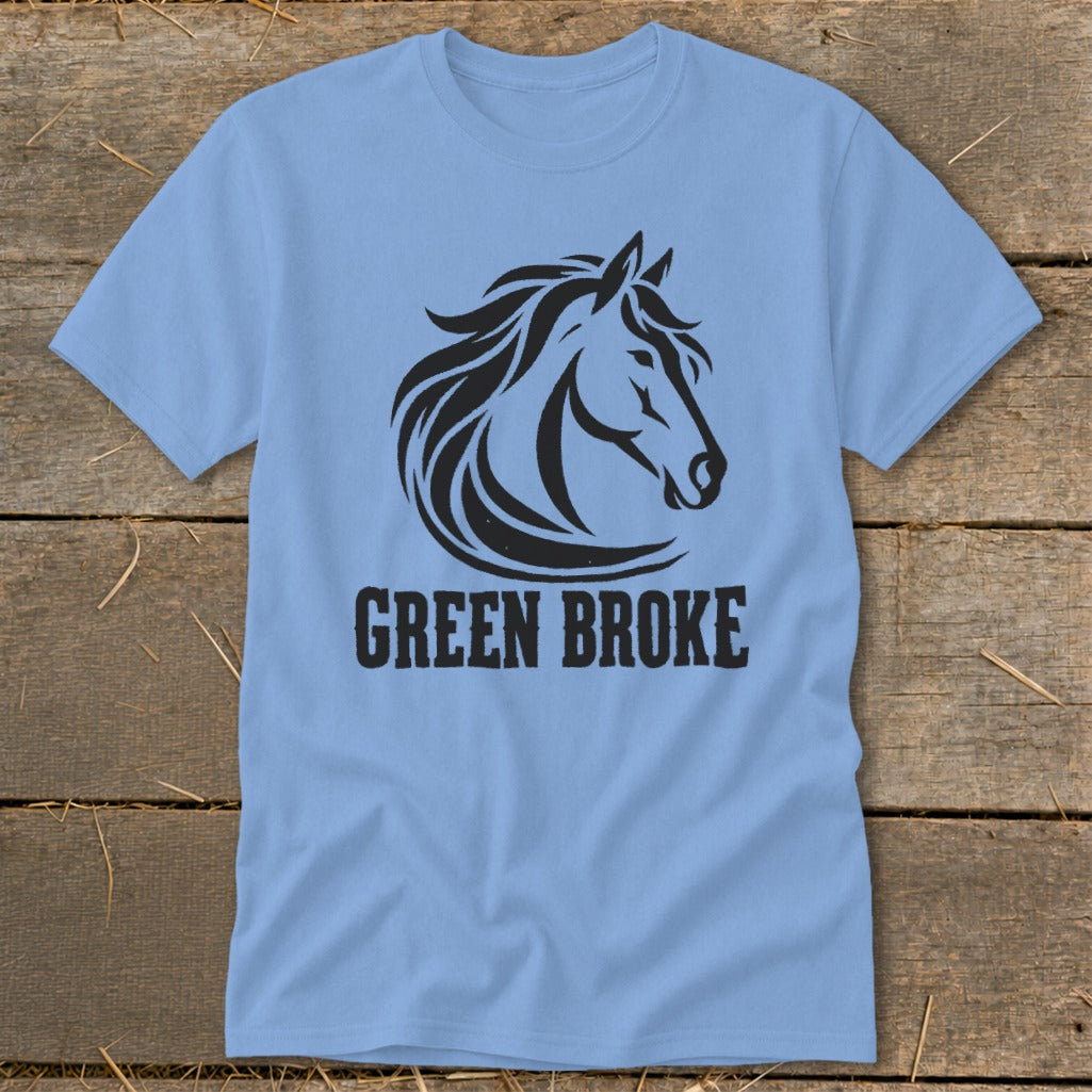 Light blue short-sleeve t-shirt with a black graphic of a horse head and text reading GREEN BROKE on a wooden surface.