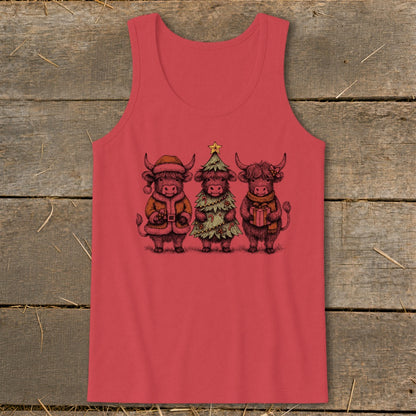 Three highland cows in Christmas attire, one as Santa, one as a tree, one holding a gift.