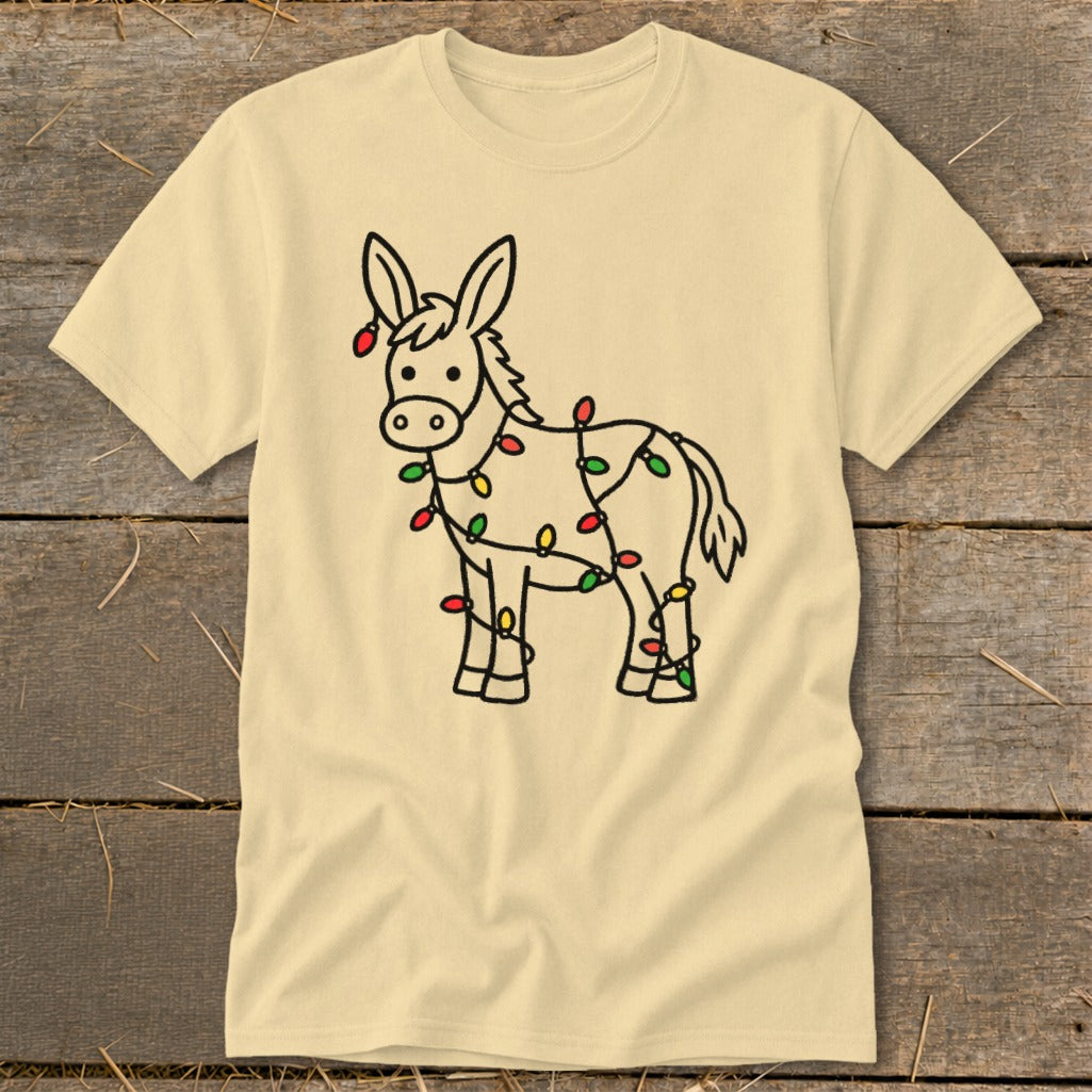 Light yellow t-shirt with a cartoon donkey wrapped in colorful Christmas lights.