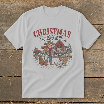White t-shirt featuring "Christmas On the Farm" graphic of a boy feeding chickens.