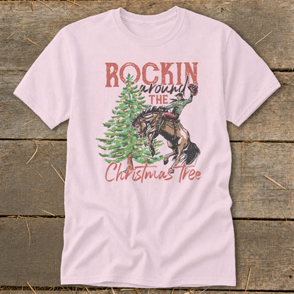 Pink t-shirt with "Rockin Around the Christmas Tree" graphic of a bucking bronco and rider.