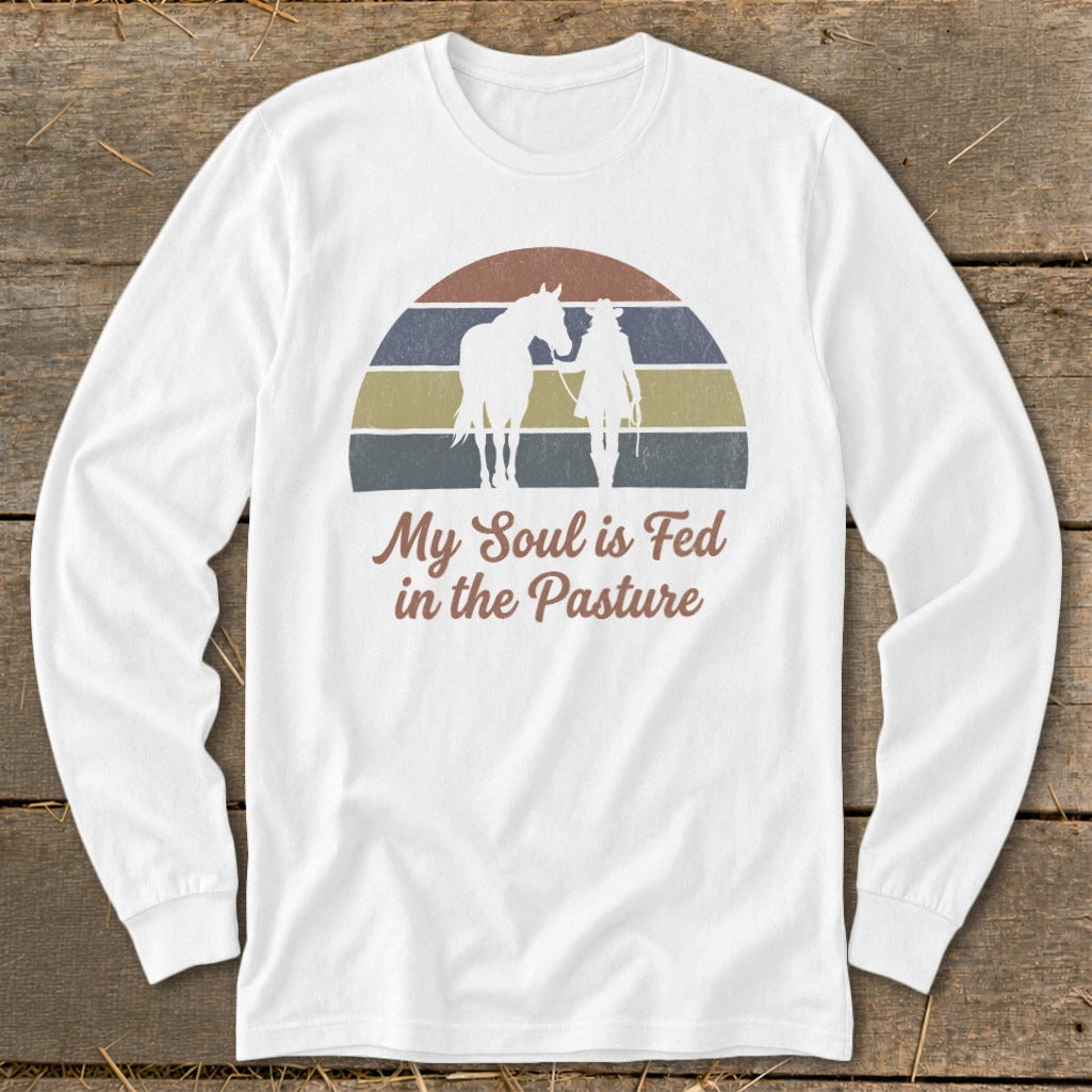White long-sleeve shirt with a graphic of a horse and person in a pasture with text.