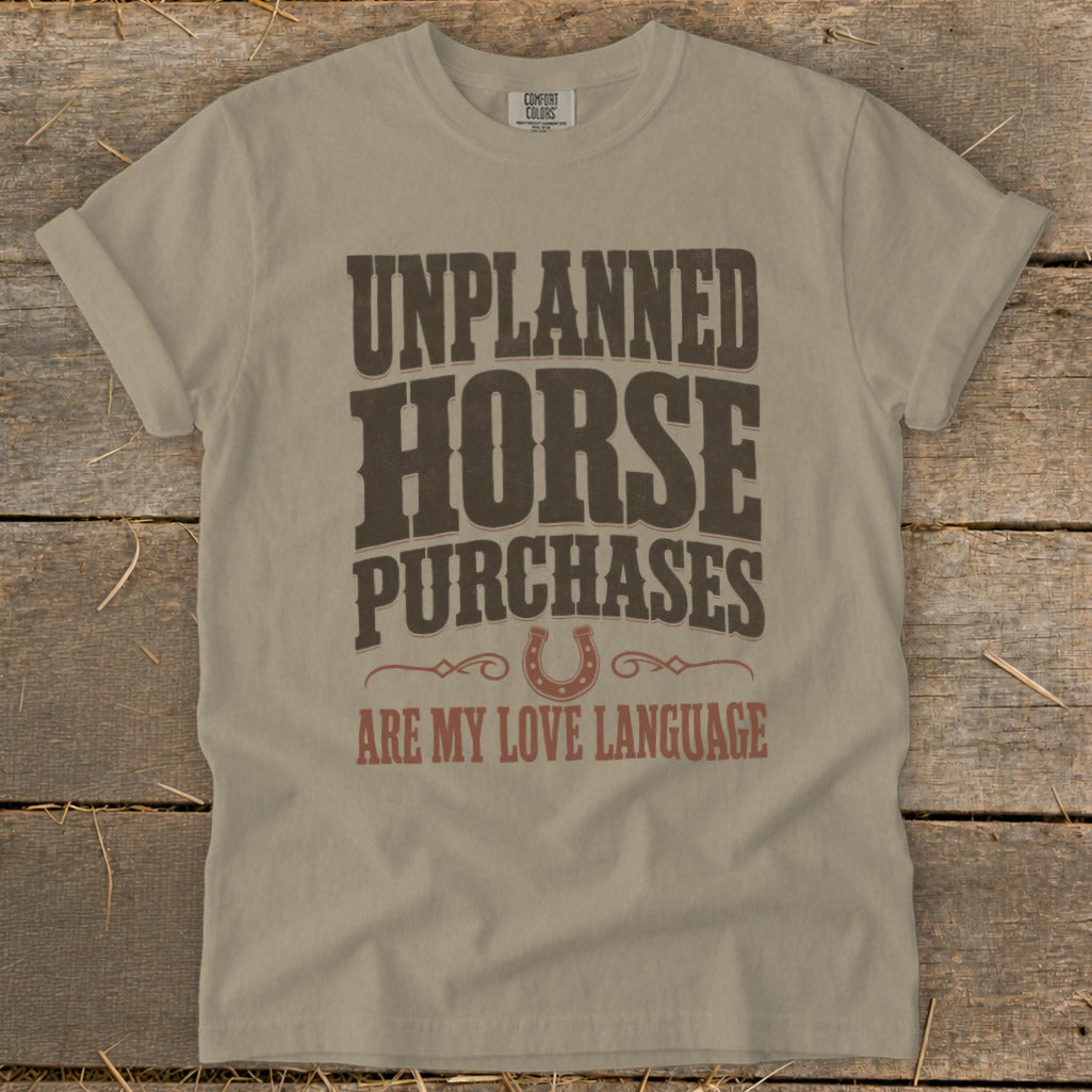 T-shirt with "Unplanned Horse Purchases Are My Love Language" text and horseshoe graphic.