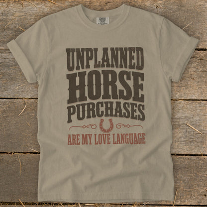 T-shirt with "Unplanned Horse Purchases Are My Love Language" text and horseshoe graphic.
