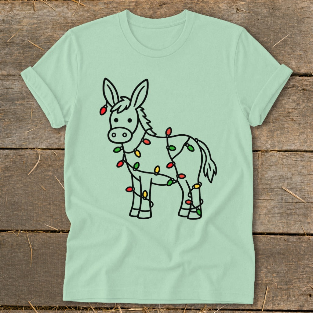 Light green t-shirt with a cartoon donkey wrapped in colorful Christmas lights.