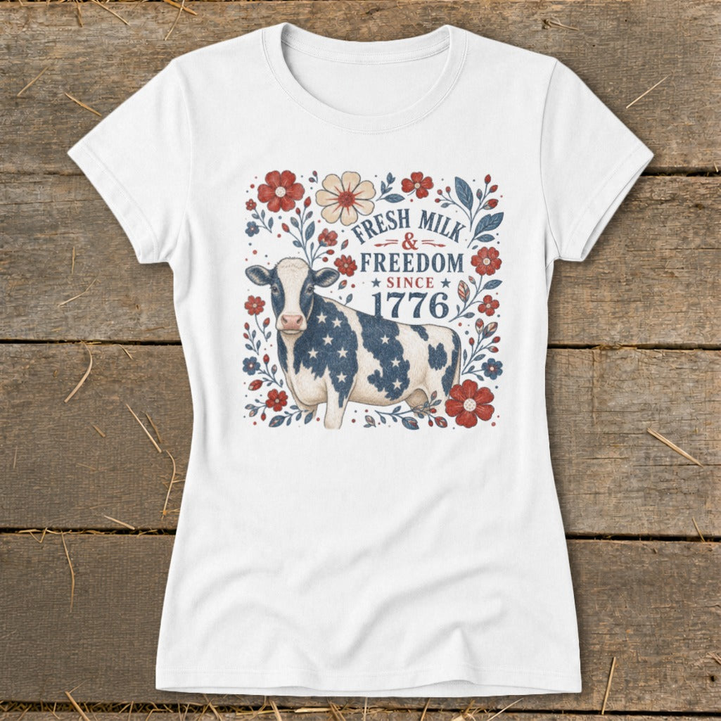 Cow with American flag pattern on a white t-shirt with "Fresh Milk & Freedom Since 1776" text.