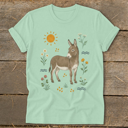 Light green t-shirt with a drawing of a donkey surrounded by flowers and sun.