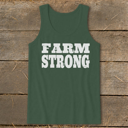 Dark green tank top featuring the white distressed text Farm Strong, laid flat on a rustic wooden surface.