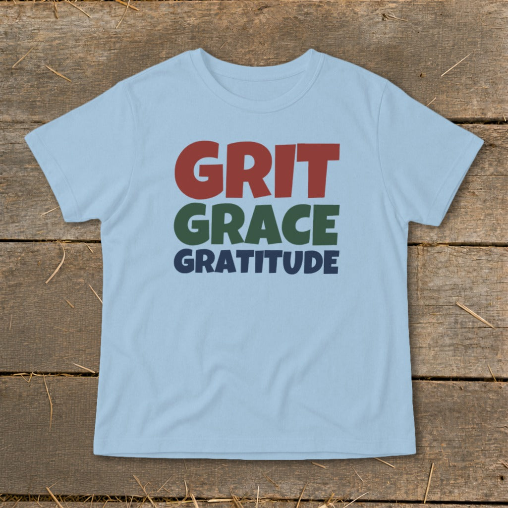 Light blue short-sleeved t-shirt with the words Grit, Grace, Gratitude printed in red, green, and blue.