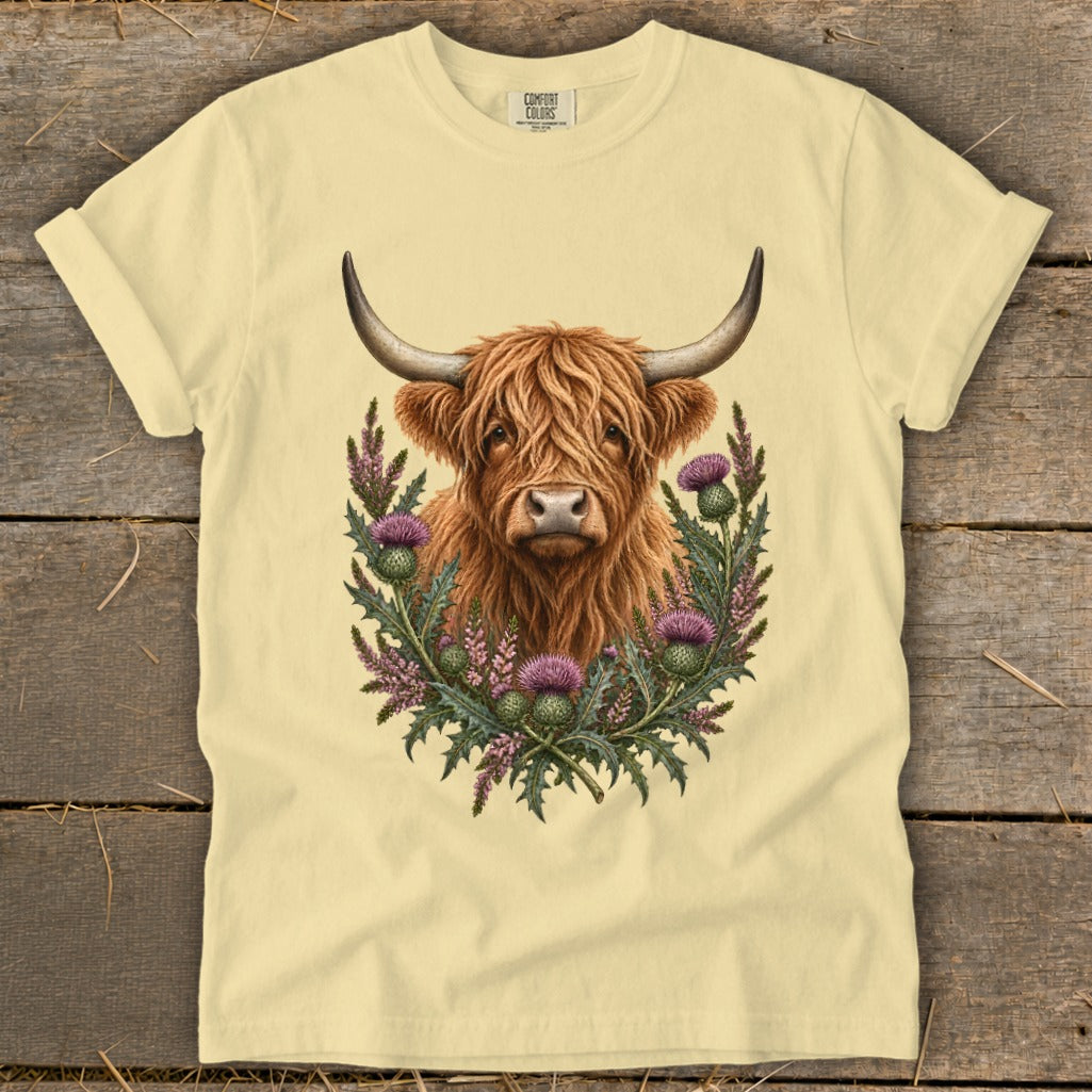 Cream t-shirt with Highland cow and thistles graphic.