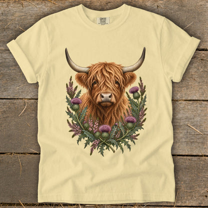 Cream t-shirt with Highland cow and thistles graphic.