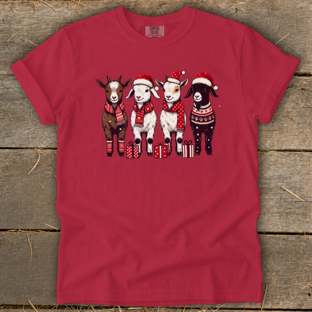Four goats in Santa hats and scarves stand with gifts.