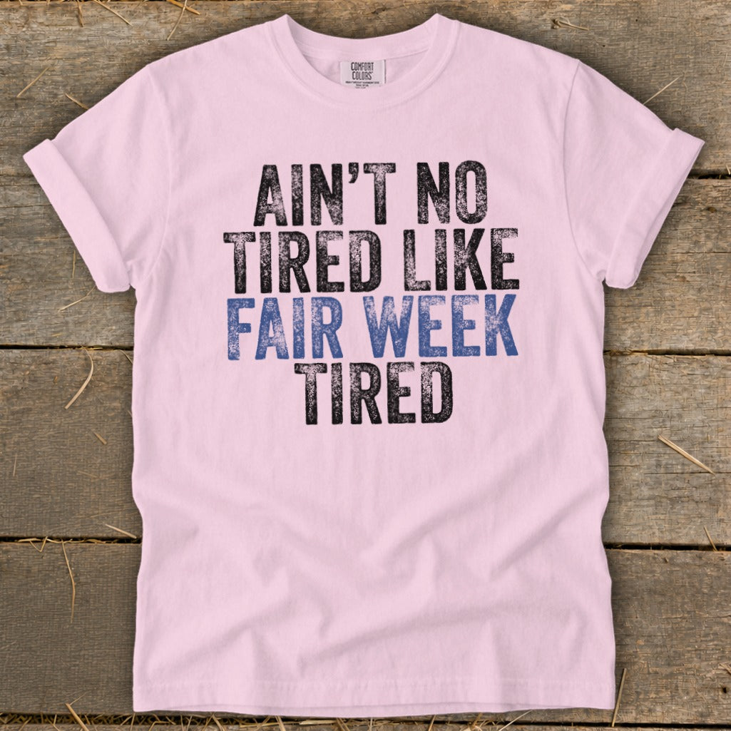 Pink t-shirt with text "AIN'T NO TIRED LIKE FAIR WEEK TIRED".