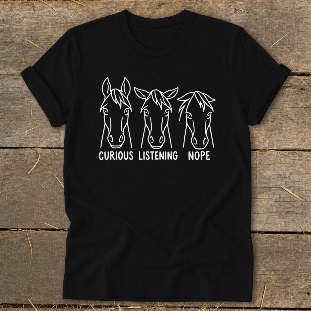 Black t-shirt featuring three horse heads with the text "CURIOUS," "LISTENING," and "NOPE" printed underneath.