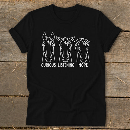 Black t-shirt featuring three horse heads with the text "CURIOUS," "LISTENING," and "NOPE" printed underneath.