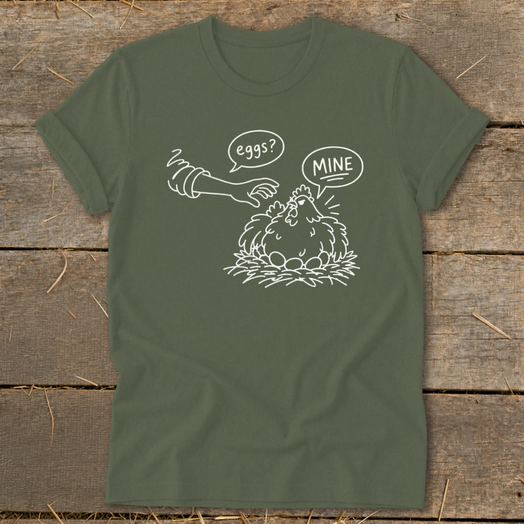 Green t-shirt with a cartoon chicken guarding eggs, speech bubbles say "eggs?" and "MINE".