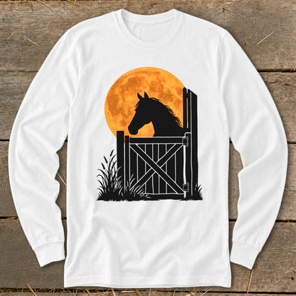 A white long-sleeved t-shirt featuring a black silhouette of a horse looking out a stable door against a large orange moon.