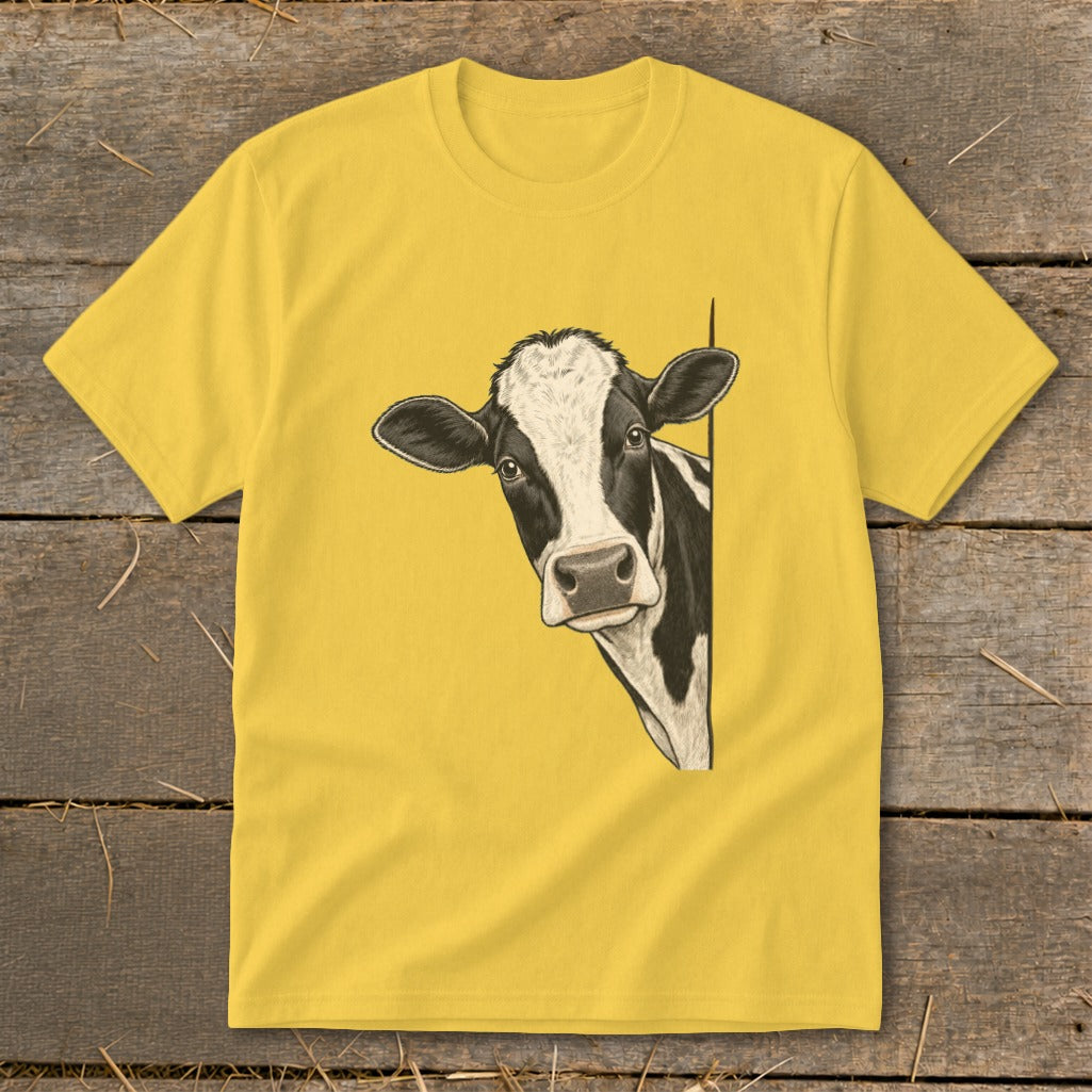 Black and white cow peeking from behind a yellow t-shirt.