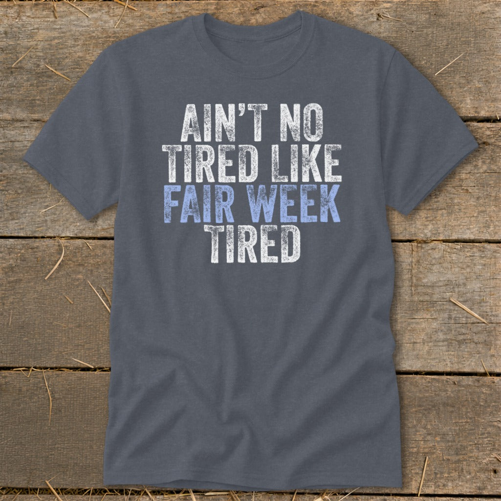 Gray t-shirt with distressed text reading "AIN'T NO TIRED LIKE FAIR WEEK TIRED".