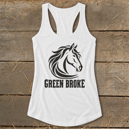 A white racerback tank top featuring a black graphic of a horse head and the text GREEN BROKE on a rustic wooden background.