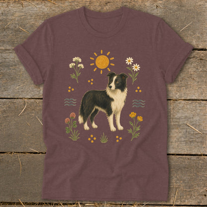 Border collie on maroon t-shirt with sun and wildflowers.