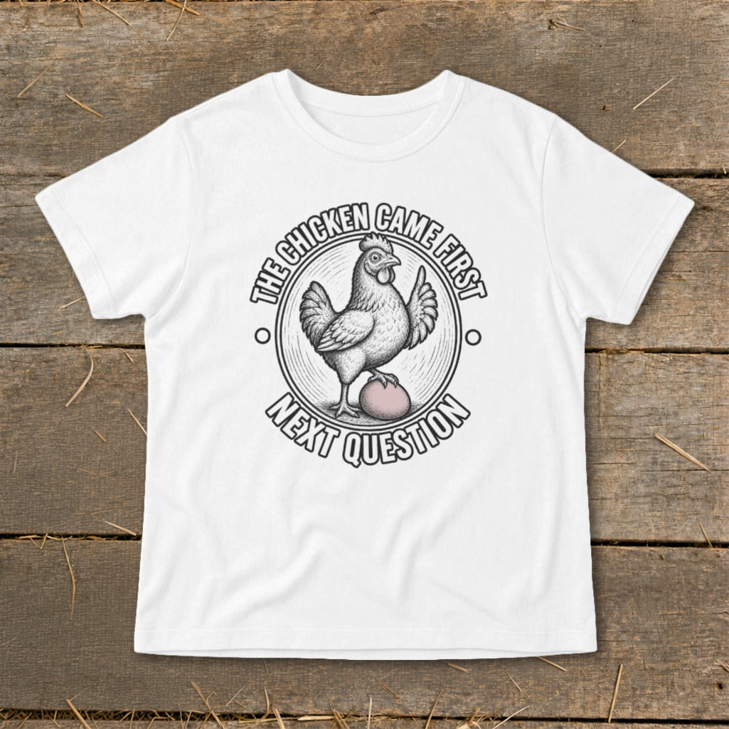White t-shirt with a circular graphic of a chicken on an egg, text reads "The chicken came first. Next question."
