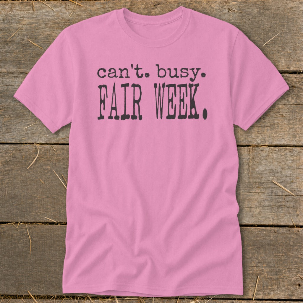 Pink t-shirt with black text "can't. busy. FAIR WEEK."
