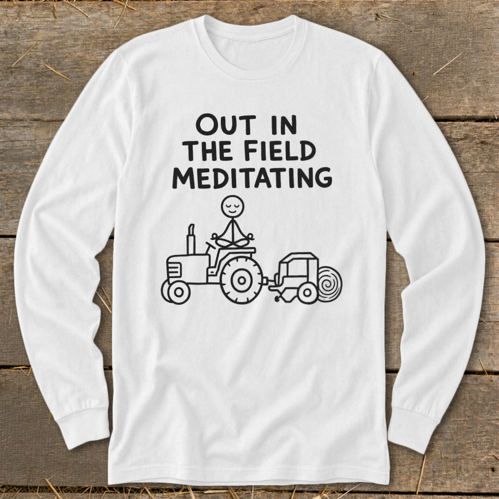 White long-sleeve shirt with black text and graphic of a stick figure meditating on a tractor.