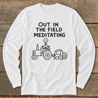 White long-sleeve shirt with black text and graphic of a stick figure meditating on a tractor.