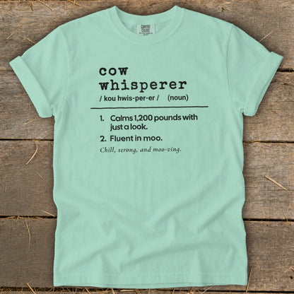 Mint green t-shirt with "Cow Whisperer" definition and related phrases.