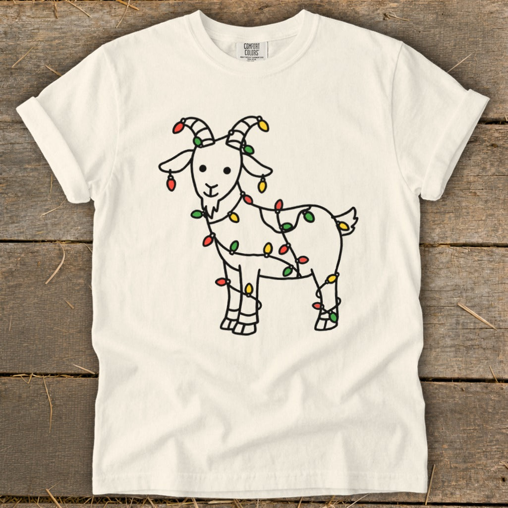 White t-shirt with a black line drawing of a goat wrapped in colorful Christmas lights.