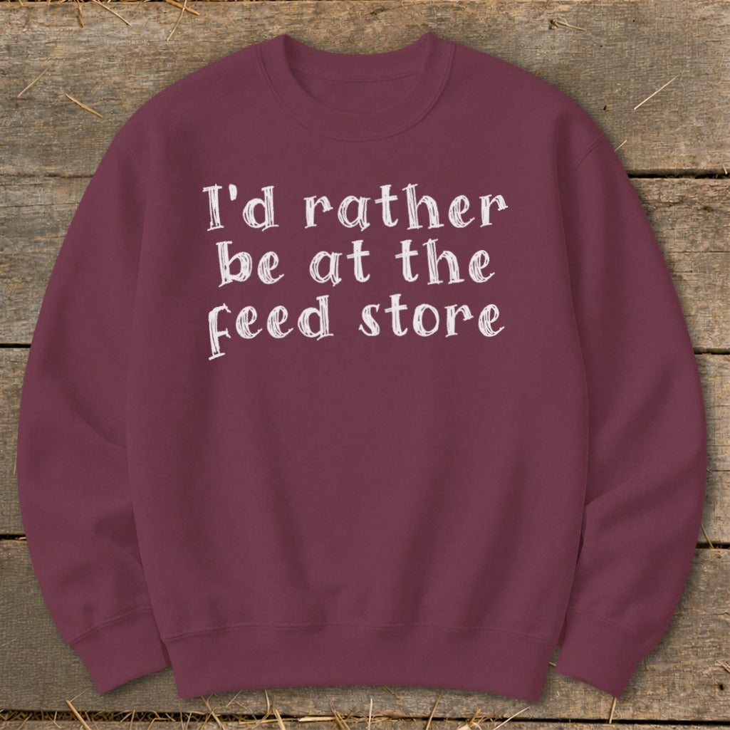 Maroon sweatshirt with white text "I'd rather be at the feed store".