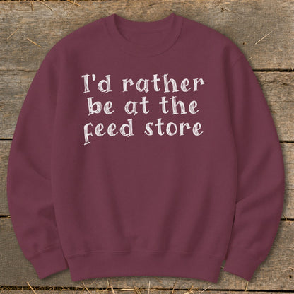 Maroon sweatshirt with white text "I'd rather be at the feed store".