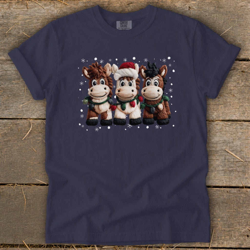 Navy t-shirt with three cartoon horses wearing scarves and Christmas lights.