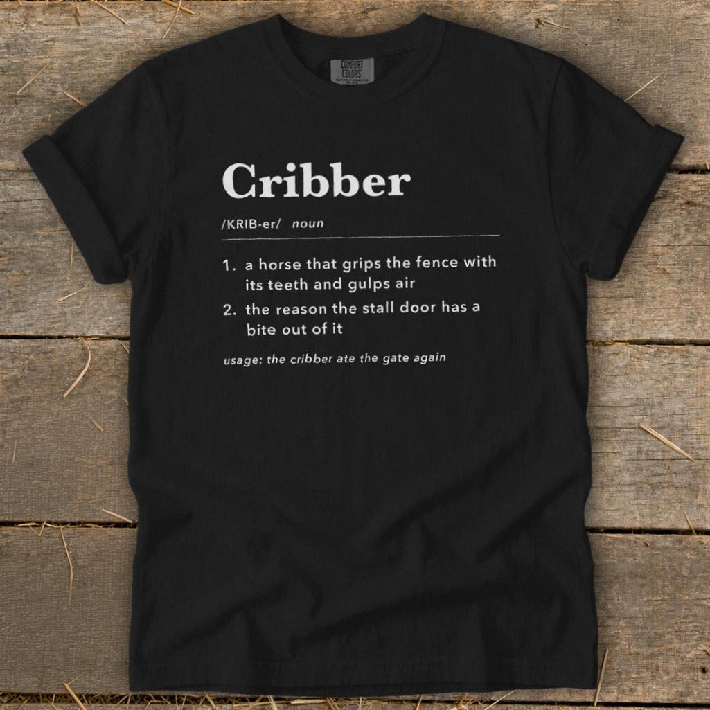 Black t-shirt featuring dictionary-style definitions for the noun cribber printed in white text on the front.