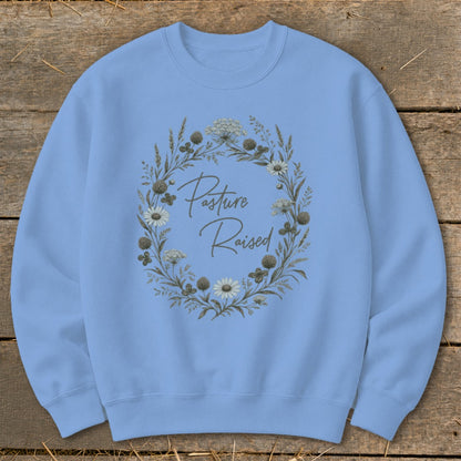 Light blue sweatshirt with "Pasture Raised" text in a floral wreath design.