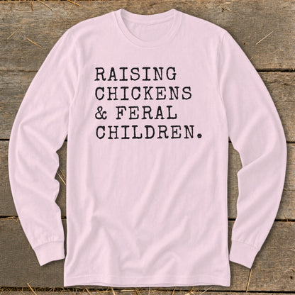 Pink long sleeve shirt with black text reading "Raising Chickens & Feral Children."