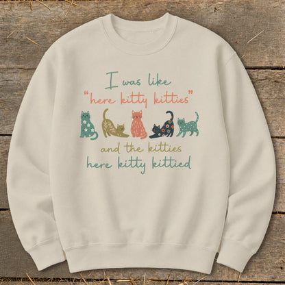 Cream sweatshirt with text and cartoon cats: "I was like 'here kitty kitties' and the kitties here kitty kittied."