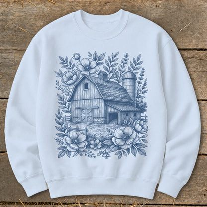 Light blue sweatshirt with a barn and floral sketch print.