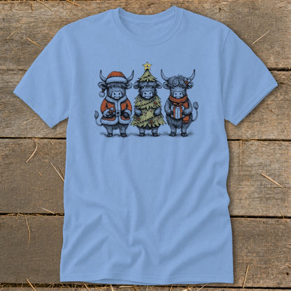 Three Highland cows dressed for Christmas, one as Santa, one as a tree, one with a gift.